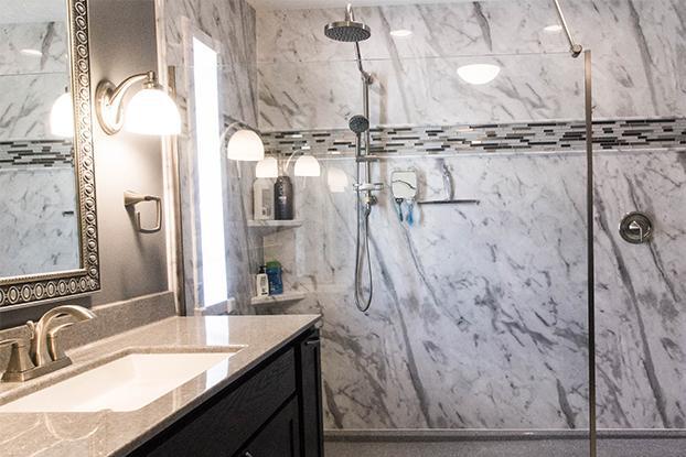 Calcutta marble DuraBath is one of the most popular solutions for all design styles whether that be traditional, contemporary or transitional. The stone slab look with the lifetime warranty and easy-to-clean nature of DuraBath is likely the reason. This walk-in shower was originally a soaking tub and is now a beautiful tub to shower conversion. The custom vanity includes a lot of custom organization including hair dryer storage, toilet paper storage and the like!