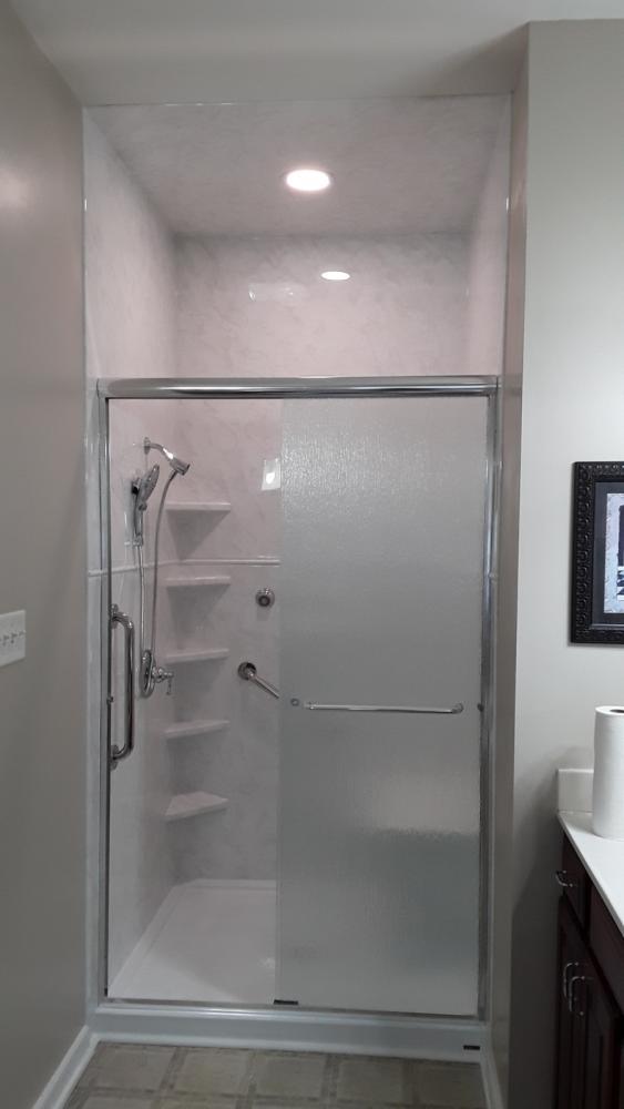 We took our acrylic walls to the ceiling and added a ceiling panel. White Marble walls will never be outdated and gives a crisp clean look. Plenty of shelving and a handheld for easy cleaning.