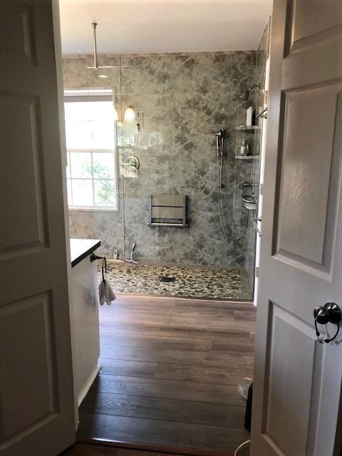 This shower does not require a door because of the size and the VIM shower and water proof system created the perfect slope without cutting floor joists. Re-Bath Gray Emperador Walls and a HDPE ( waterproof ) folding seat from Health at Home Inc create a shower that is so easy to maintain. Bathroom Floor is LVP from Armstrong A6913 Carmego Oak Nickel Mine.