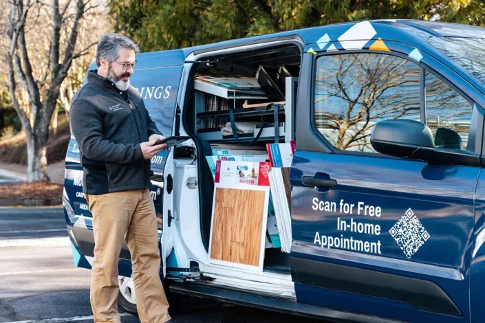 man in font of floor coverings international van